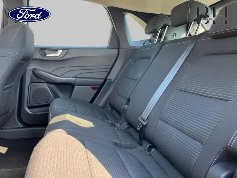 Vue latérale intérieure montrant la banquette arrière en tissu noir du Ford Kuga 2022, avec ceinture de sécurité et appuie-têtes.