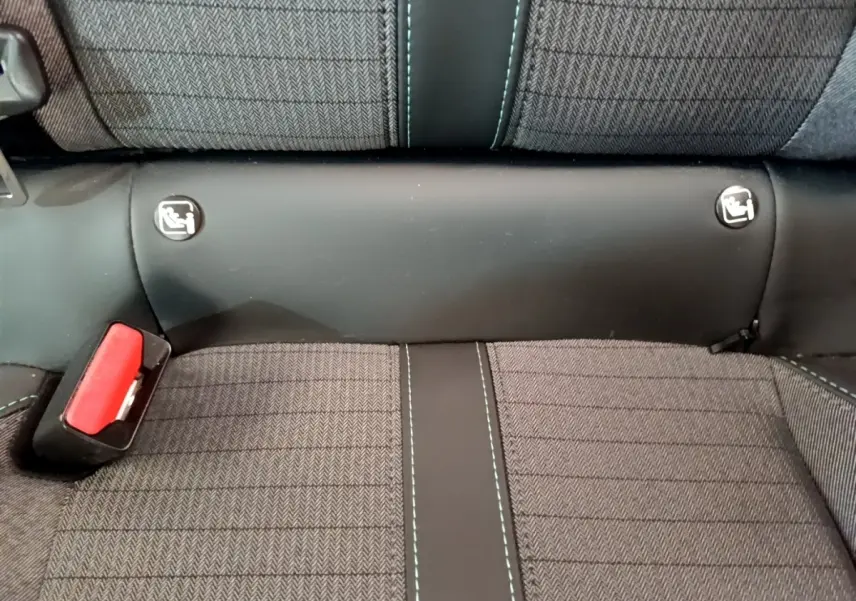 Détail de la banquette arrière grise avec surpiqûres bleues et attaches Isofix visibles sur Peugeot 208 PureTech 100.