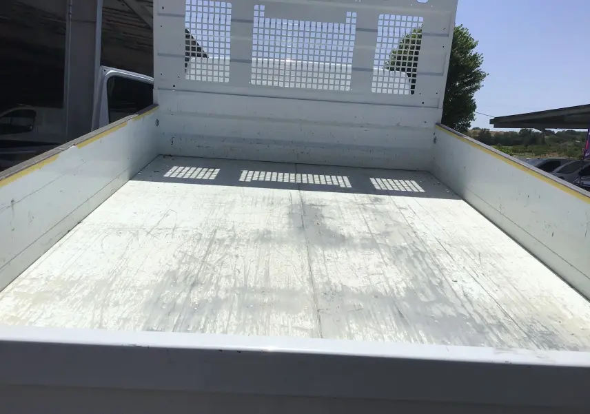 Vue plongeante sur la benne blanche arrière du Renault Master Châssis cabine 2024 avec ridelle perforée et surface usée.