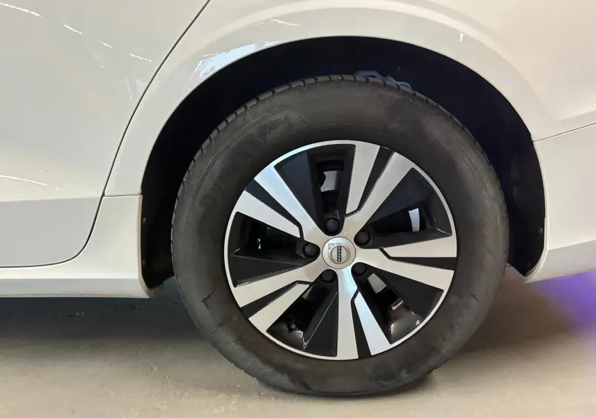 Gros plan sur la roue arrière droite blanche d'une Volvo V60 D3 2.0 150 Executive avec jante noire et argentée.