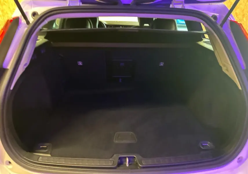 Coffre ouvert d’un Volvo V60 blanc 2020, vue arrière montrant un espace de chargement vide et propre.