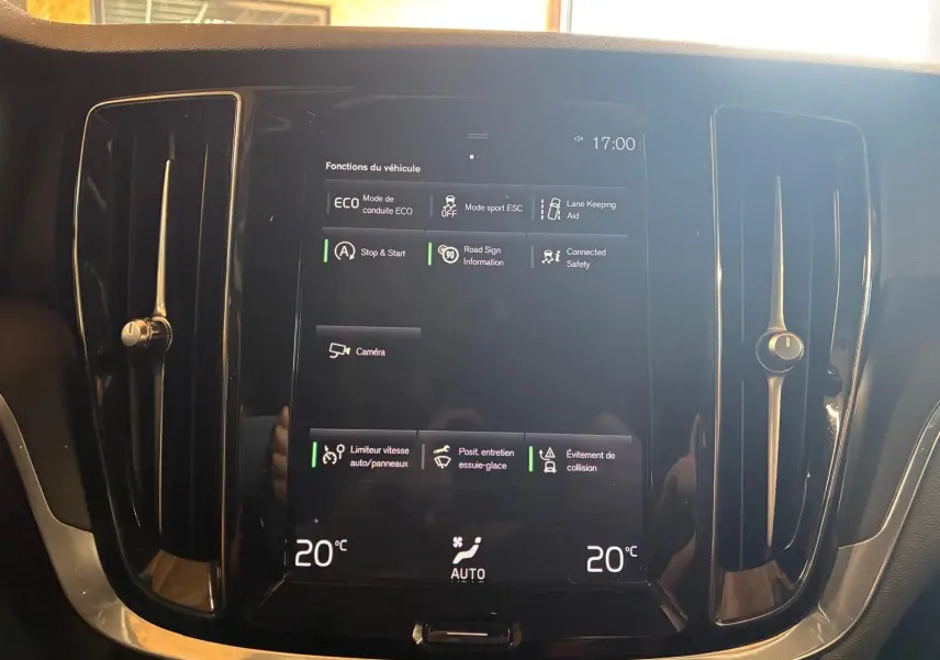 Écran tactile central du tableau de bord d’une Volvo V60 D3 2020, affichant les fonctions du véhicule et la climatisation à 20°C.