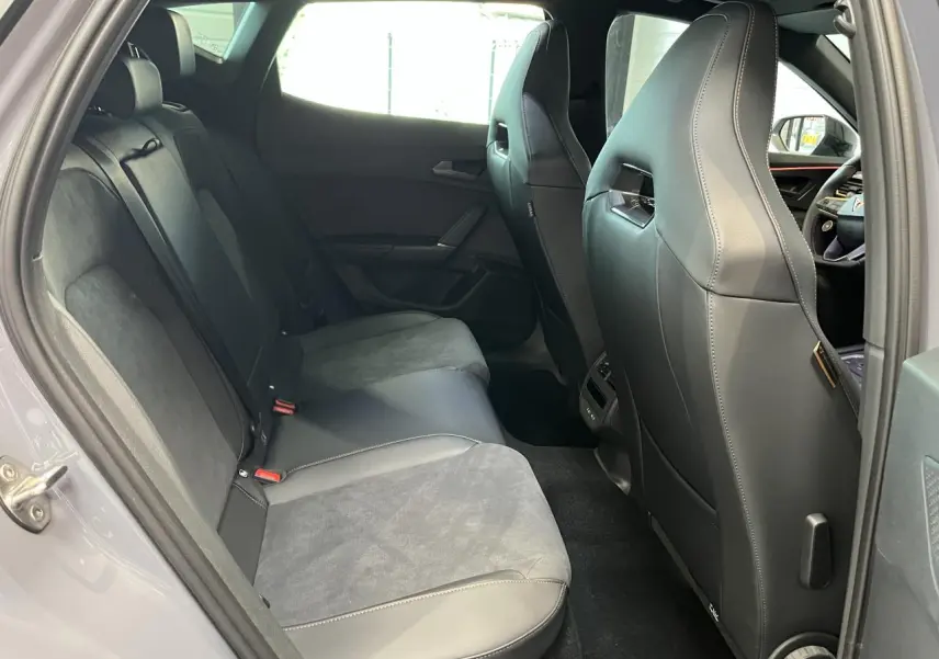 Vue intérieure côté gauche des sièges arrière en cuir et alcantara gris clair du CUPRA Formentor 2025 avec détails couture contrastés.