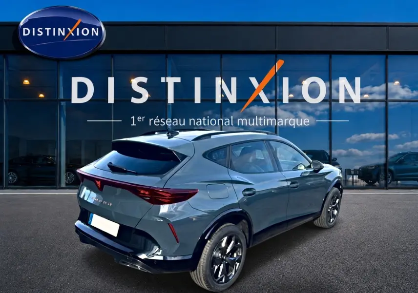 Vue 3/4 arrière droite d'une CUPRA Formentor bleu fjord avec jantes noires devant une vitrine Distinxion.