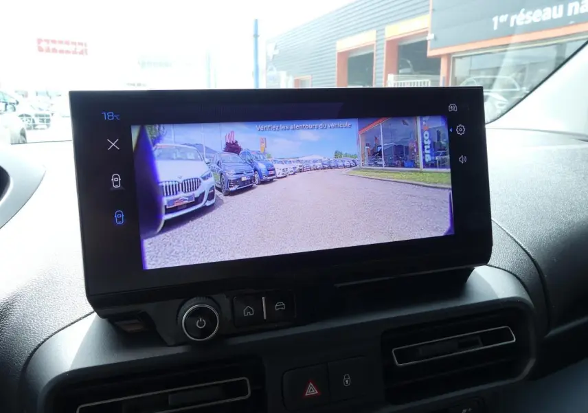 Écran tactile intérieur du Peugeot Partner XL affichant la caméra de recul avec vue sur un parking extérieur.