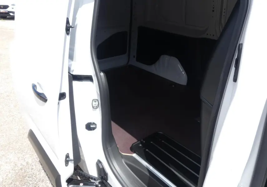 Vue rapprochée de l'ouverture de la porte latérale droite du Peugeot Partner XL blanc, montrant l'intérieur vide et le seuil de chargement.