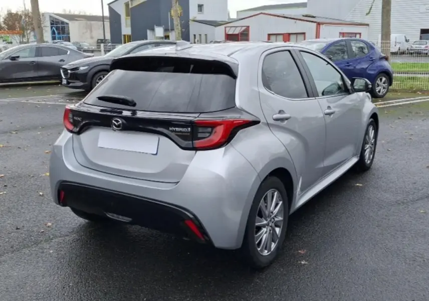 Vue 3/4 arrière droite d'une Mazda2 Hybrid argent 2022 avec feux arrière distinctifs et vitre arrière teintée.