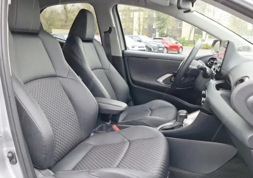 Vue intérieure côté gauche de la Mazda2 Hybrid 2022 avec sièges avant en cuir noir et console centrale visible.
