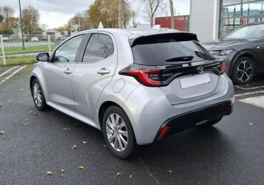 Vue 3/4 arrière droite d'une Mazda2 hybride 2022 argent avec vitres teintées et feux arrière distinctifs.