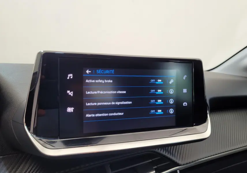Écran tactile central affichant les options de sécurité dans l'habitacle d'une Peugeot 208 gris foncé 2023.