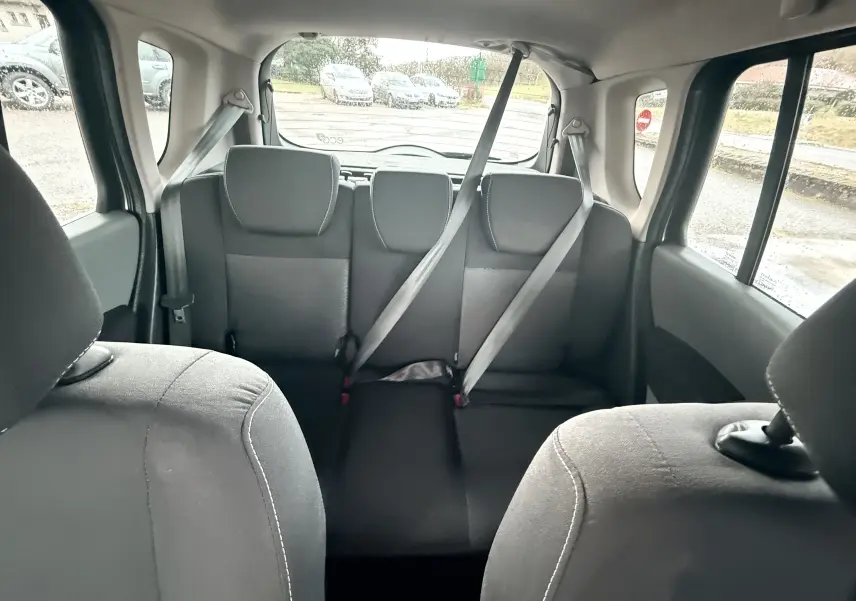 Vue intérieure arrière montrant les sièges arrière gris-noir en tissu d'une Renault Modus beige de 2011.