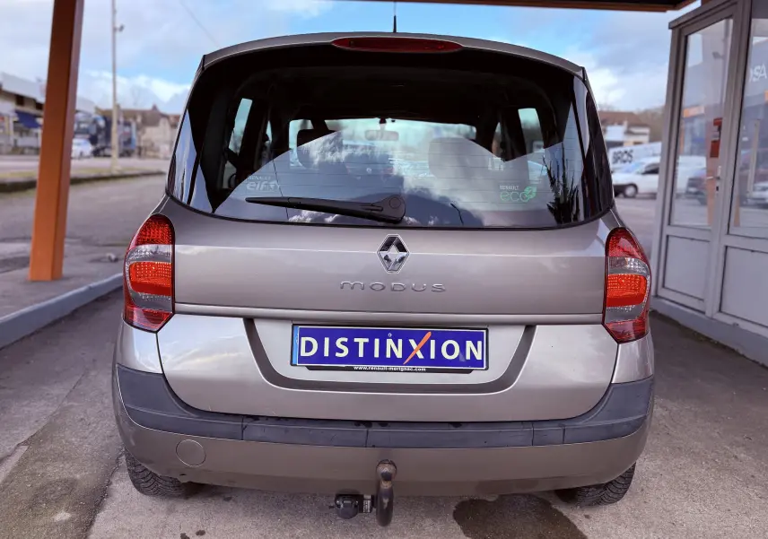 Vue arrière d'une Renault Modus beige de 2011 avec attelage et plaque d'immatriculation Distinxion.