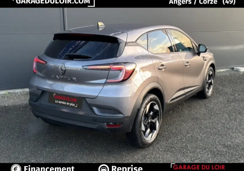 Vue 3/4 arrière droite d’un Renault Captur Techno TCe 90 gris foncé avec jantes noires distinctives, année 2025.
