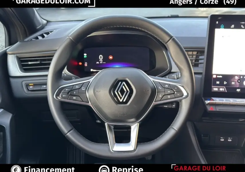 Vue intérieure centrée sur le volant du Renault Captur 2025, avec tableau de bord numérique et écran tactile visible.