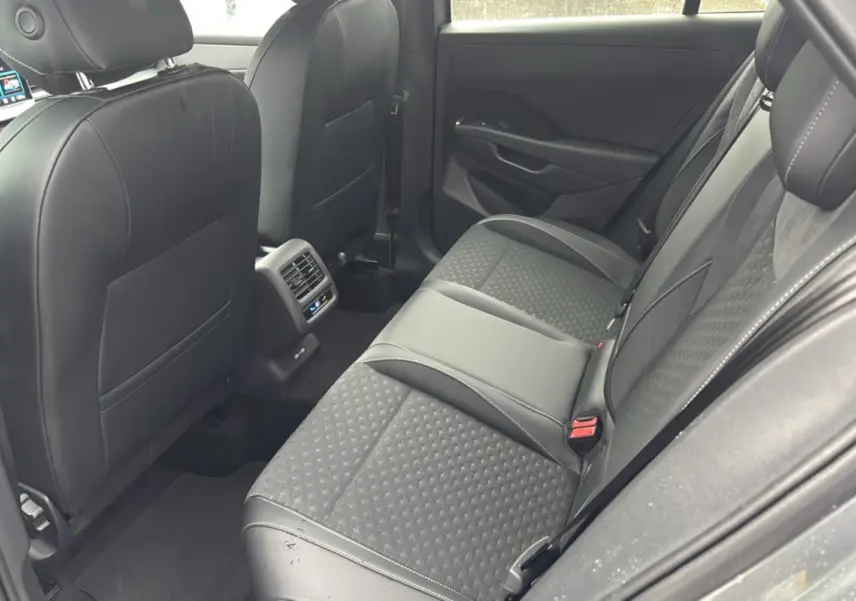 Vue intérieure montrant la banquette arrière en tissu gris et cuir noir du Volkswagen T-Roc ETSI 150 DSG7 R-Line 2026.