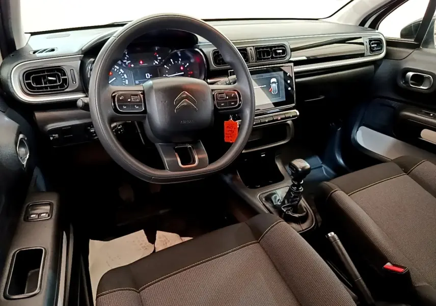 Vue intérieure avant de la Citroën C3 2021, tableau de bord noir avec écran tactile et volant multifonctions.