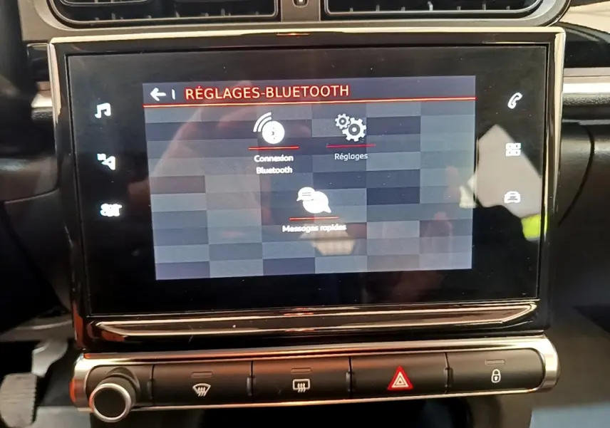 Écran tactile central affichant les réglages Bluetooth dans l’habitacle noir d’une Citroën C3 blanche, vue de face.