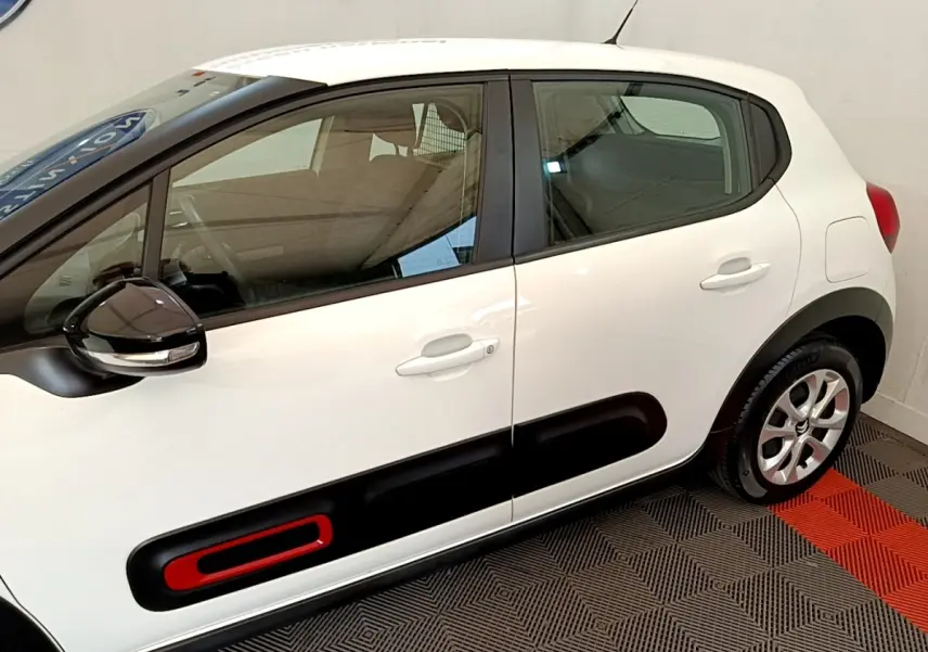 Vue latérale droite d'une Citroën C3 blanche 2021 avec protection latérale noire et insert rouge sur porte.