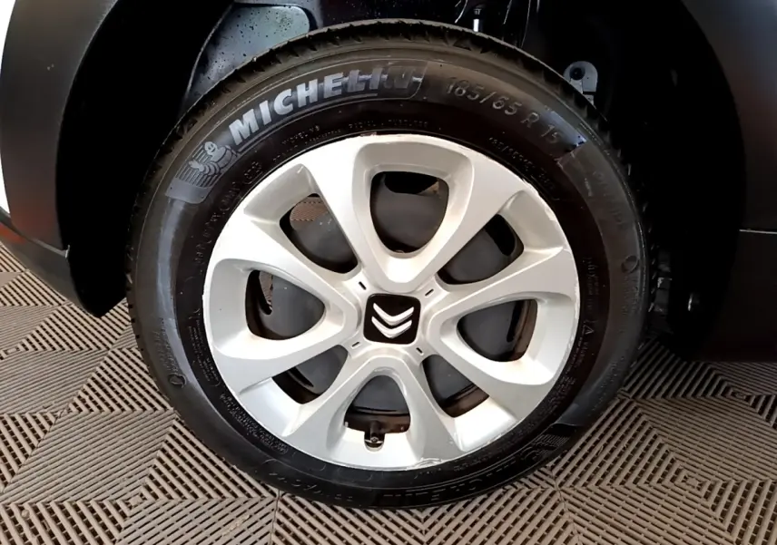 Gros plan sur la roue avant gauche d'une Citroën C3 blanche, avec jante alliage et pneu Michelin visible.