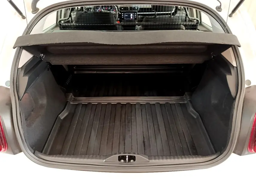 Vue arrière du coffre ouvert d'une Citroën C3 blanche, montrant l'espace de chargement et la grille de séparation intérieure.