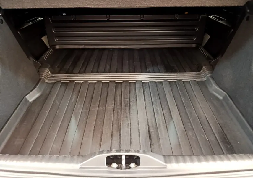 Coffre ouvert d'une Citroën C3 blanche 2021, vue intérieure montrant le tapis de coffre noir et les parois grises.