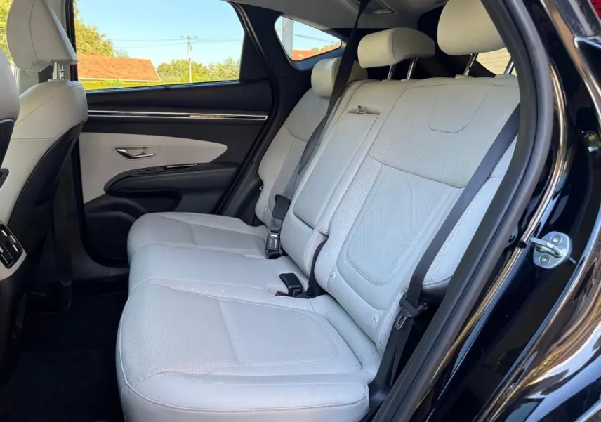 Vue côté droit de la banquette arrière claire du Hyundai Tucson noir 2022, avec ceinture de sécurité et porte ouverte.