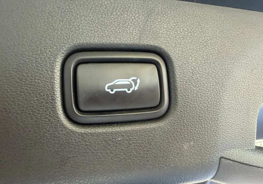 Bouton noir de commande d'ouverture du hayon sur tableau de bord intérieur du Hyundai Tucson noir 2022.