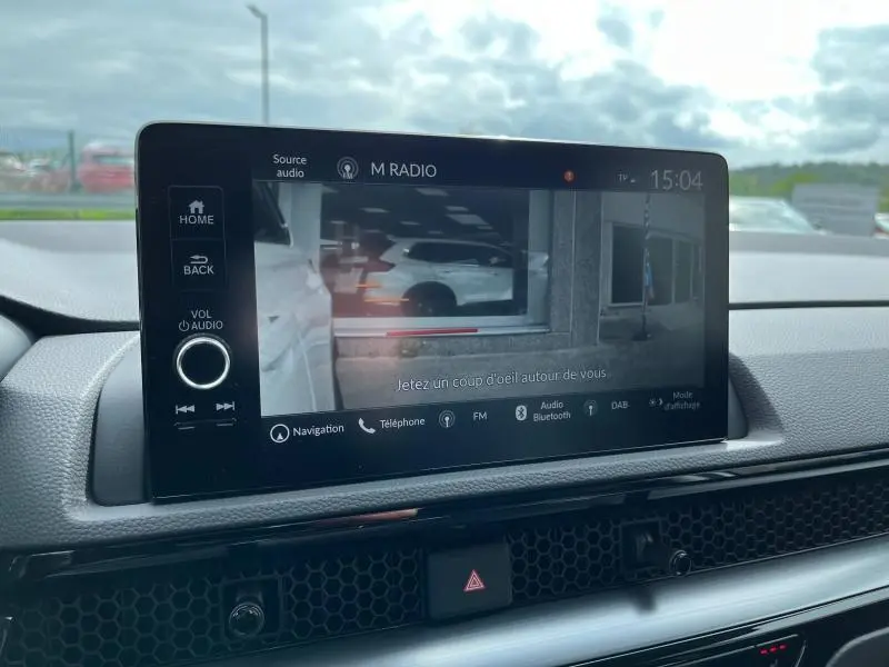 Écran tactile central du Honda CR-V 2024 montrant la caméra de recul avec vue arrière extérieure partielle.