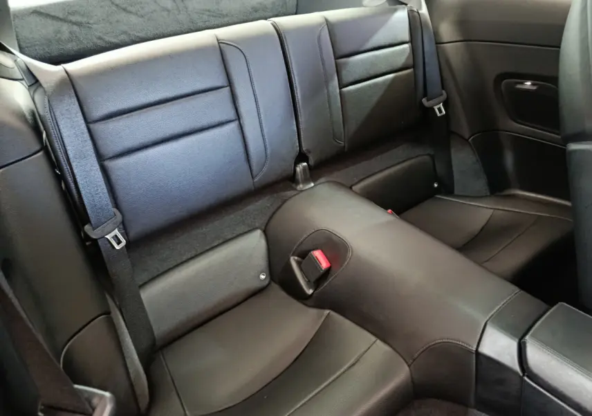 Vue rapprochée de la banquette arrière en cuir noir de la Porsche 911 Carrera 4S Coupé 2019, avec ceintures visibles.