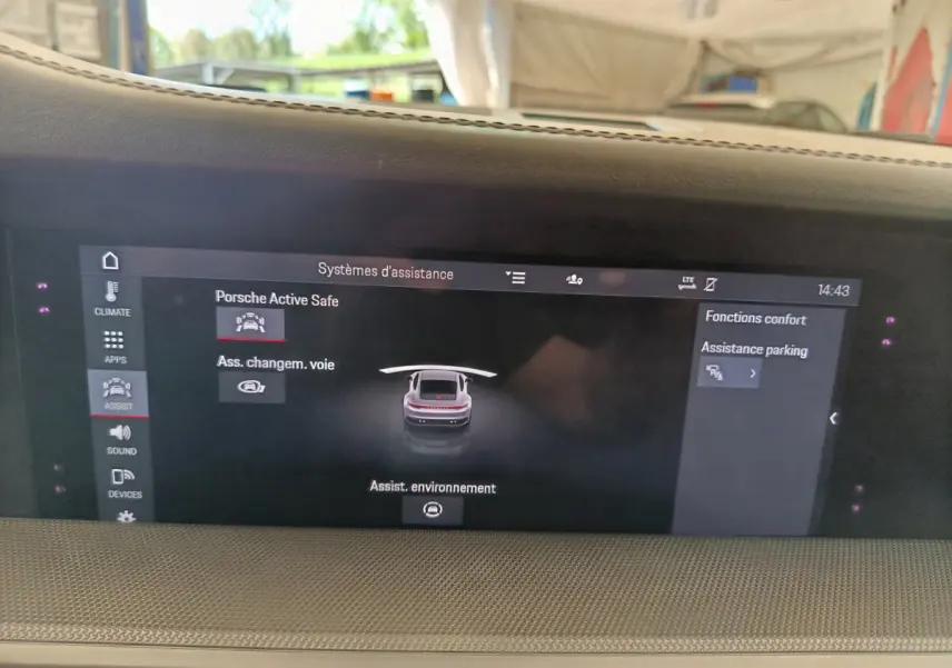Écran tactile central affichant les aides à la conduite dans l'habitacle d'une Porsche 911 Carrera 4S Coupé gris foncé.