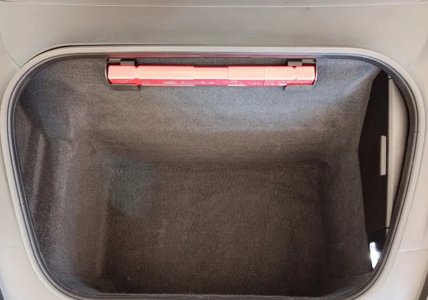 Coffre avant vide en tissu gris foncé de la Porsche 911 Carrera 4S Coupé 2019 vu de dessus avec triangle de signalisation rouge.