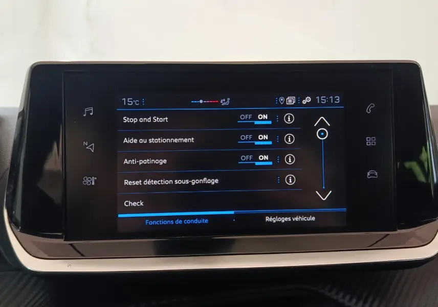 Écran tactile central de la Peugeot 208 PureTech 100 blanc affichant les réglages d'aide à la conduite.