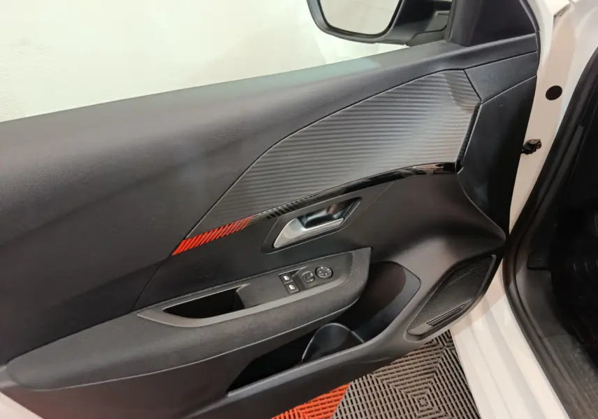 Vue rapprochée de la porte avant gauche blanche d'une Peugeot 208 2020, avec garniture noire et insert rouge.