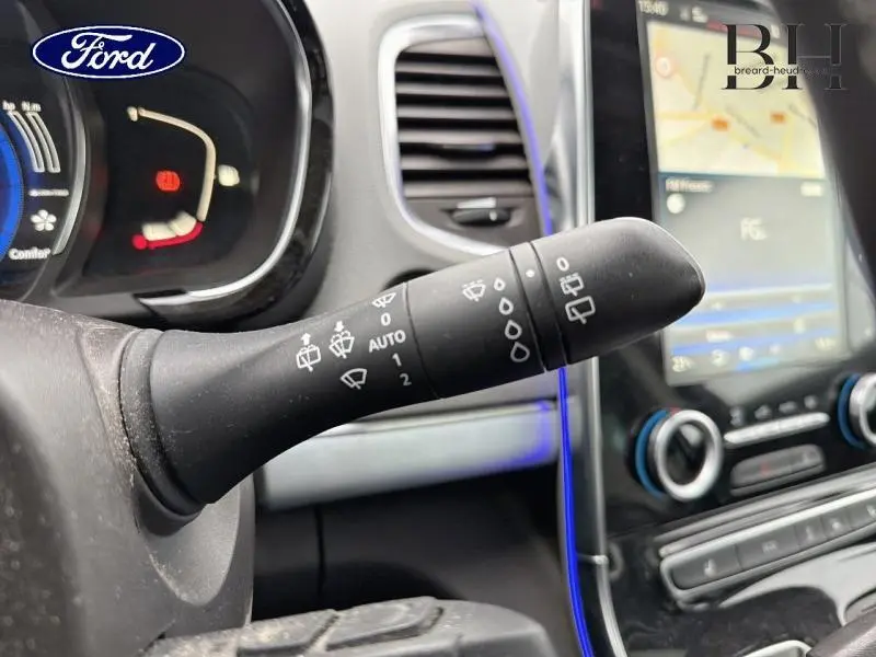 Le véhicule visible est un Renault Espace blanc Glacier, vu de l'avant côté gauche, mettant en valeur la calandre et les phares LED.