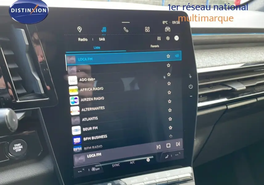 Intérieur du Renault Espace VI hybride 2024, vue sur l'écran tactile central affichant les stations radio, finition noire.