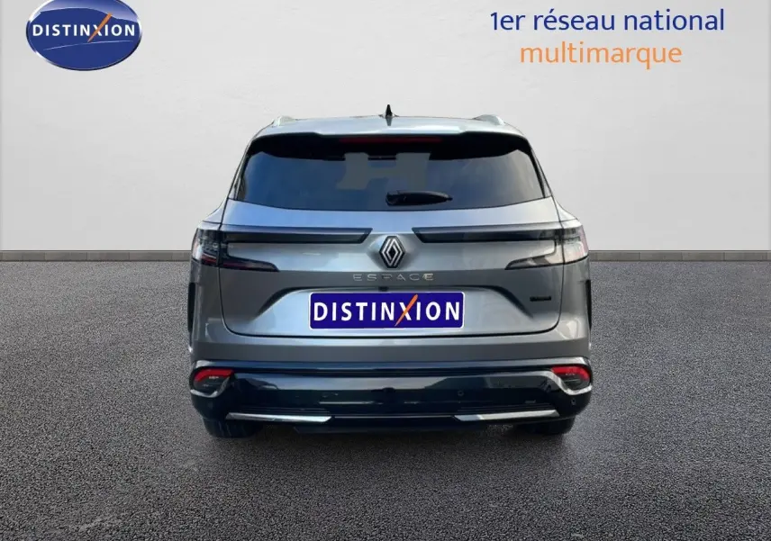 Vue arrière d’un Renault Espace 2024 gris schiste métal avec feux arrière horizontaux et logo central lumineux.