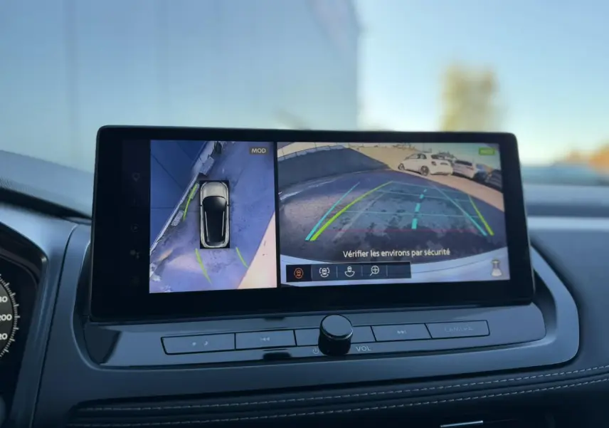 Écran central intérieur montrant la caméra de recul et la vue 360° du Nissan Qashqai blanc nacré 2025.