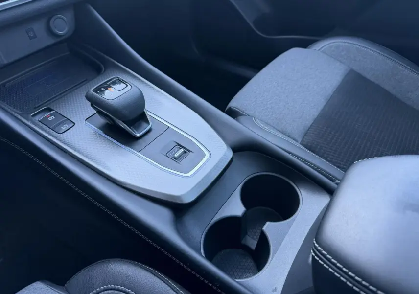 Vue rapprochée de la console centrale du Nissan Qashqai 2025, avec levier de vitesse automatique et accoudoir noir.