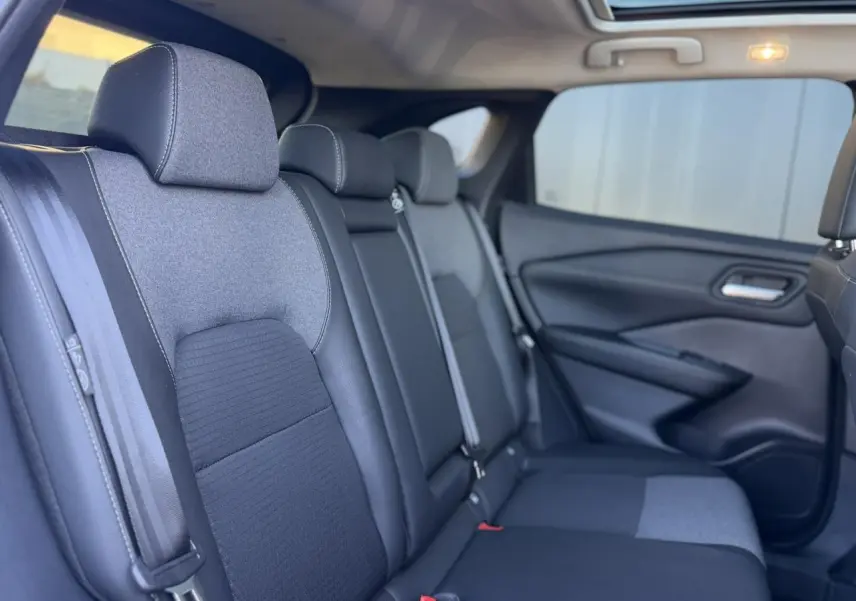 Vue intérieure côté droit des sièges arrière en tissu et TEP noir du Nissan Qashqai 2025 avec ceinture de sécurité visible.
