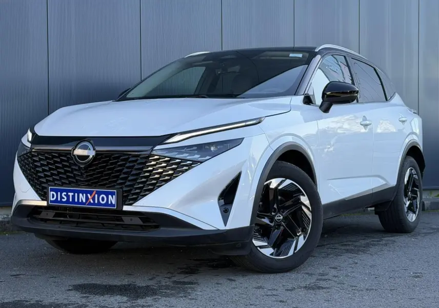 Nissan Qashqai blanc nacré avec toit noir, vue 3/4 avant, calandre noire et jantes alliage bicolores.