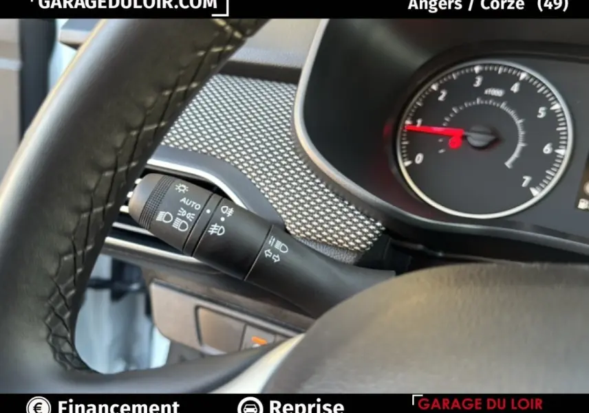 Détail du commodo d’éclairage à gauche du volant dans une Dacia Sandero blanche 2025, version Expression TCe 90.