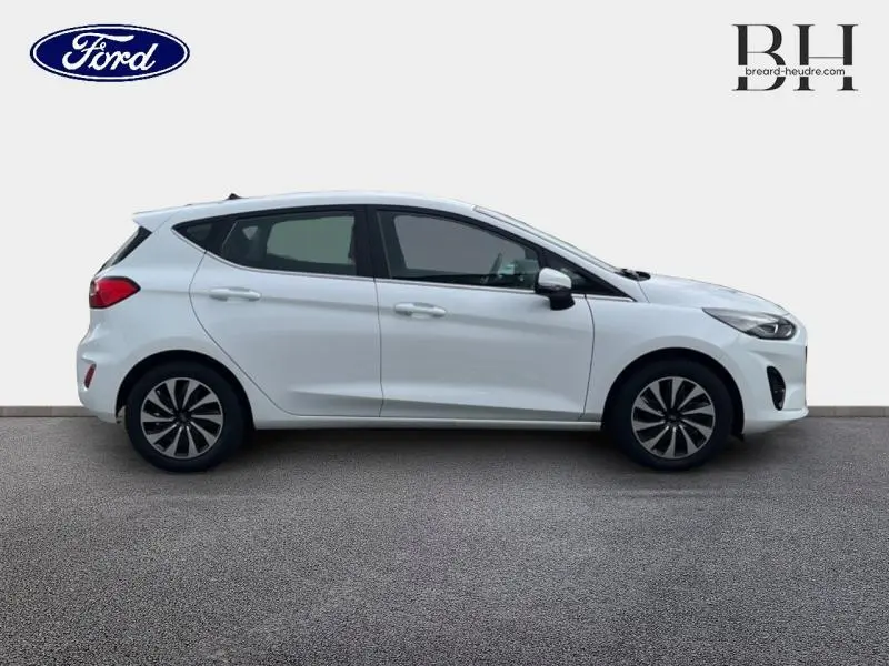 Vue latérale droite d'une Ford Fiesta blanche Glacier 2022 avec jantes alliage et poignées ton carrosserie.