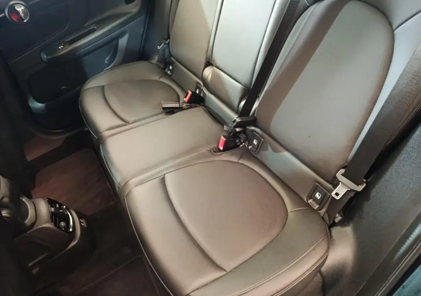 Vue intérieure du siège arrière noir en cuir du MINI COUNTRYMAN Cooper SE 2023, avec ceintures et ancrages Isofix visibles.