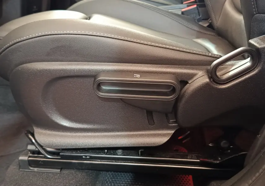 Détail côté gauche du siège avant noir du MINI Countryman Cooper SE 2023, avec commande de réglage manuelle.