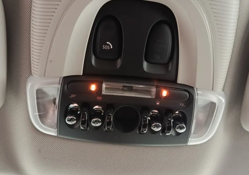 Vue en gros plan du plafonnier intérieur avec interrupteurs et boutons chromés du MINI Countryman noir 2023.