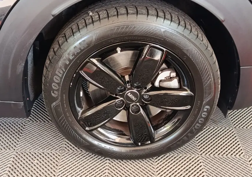 Gros plan sur la roue avant droite noire brillante d’un MINI Countryman Cooper SE 2023 avec pneu Goodyear.