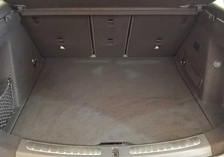 Coffre spacieux vu de face, intérieur noir avec filet de rangement sur le côté gauche, MINI Countryman 2023.