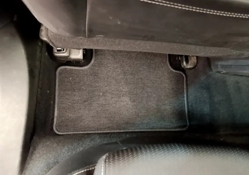 Vue intérieure du tapis de sol noir côté passager avant de la Renault Mégane Business E-Tech hybride rechargeable blanche 2022.