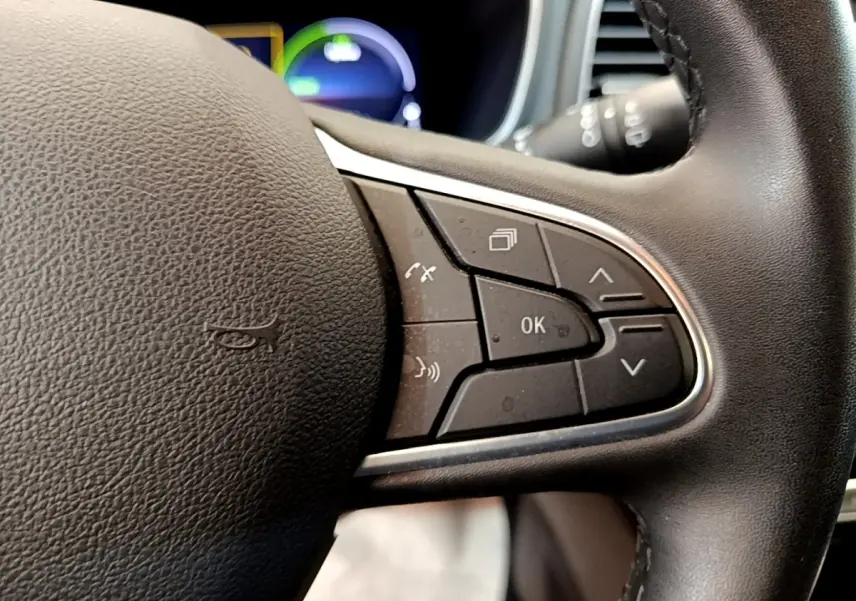 Gros plan sur les commandes multifonctions du volant noir de la Renault Mégane Business E-Tech hybride rechargeable 2022.