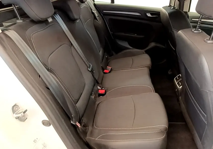 Vue côté gauche sur la banquette arrière noire de la Renault Mégane Business E-Tech hybride rechargeable blanche, avec ceintures visibles.